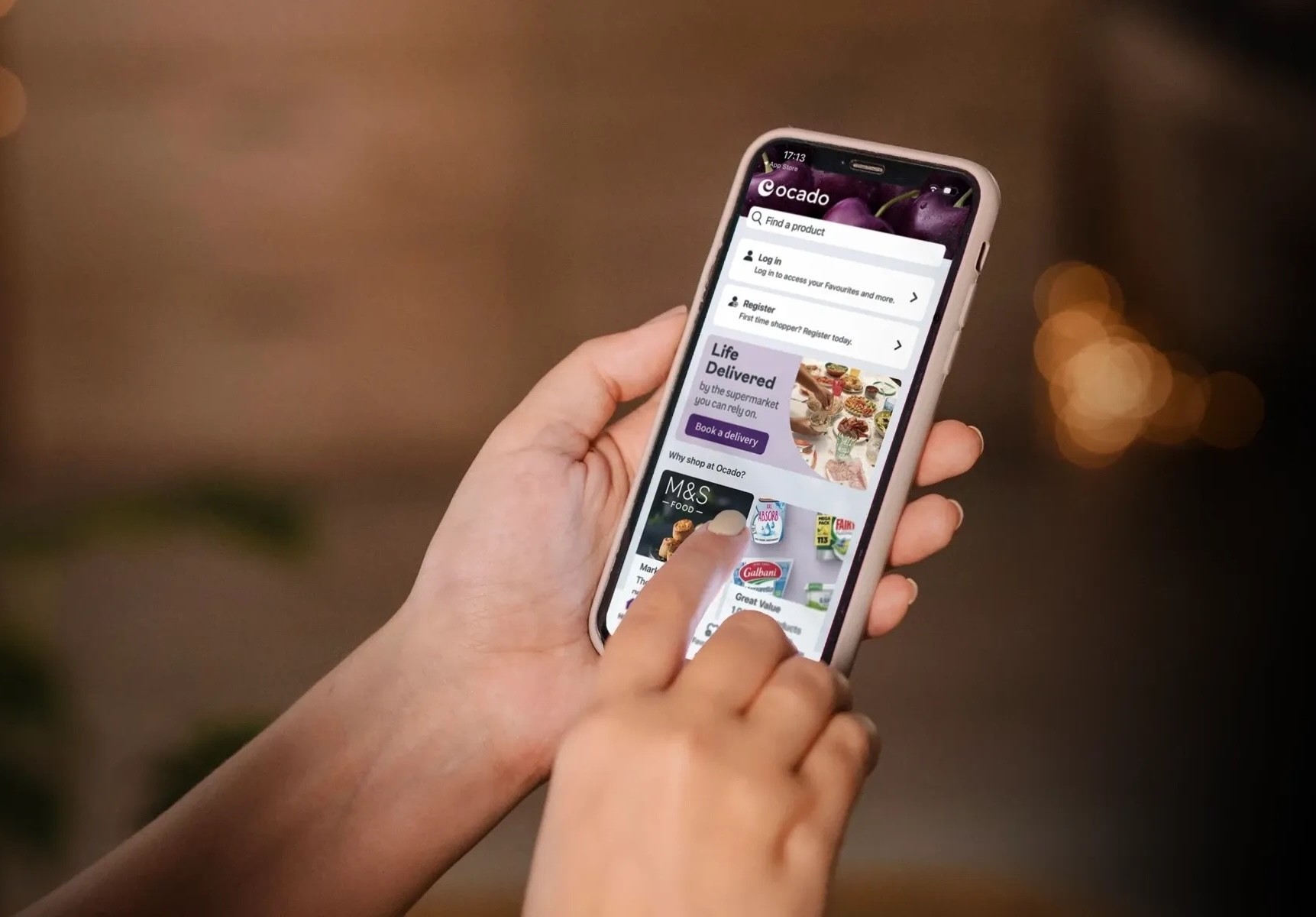A picture of someone holding a mobile phone and interacting with the ocado moible app